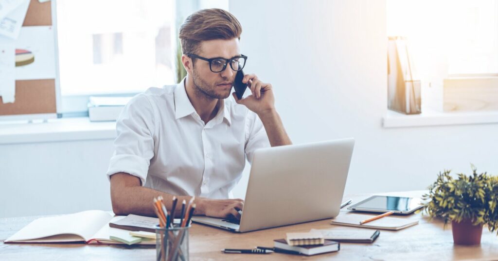 Landlord on phone and computer in Raleigh property management